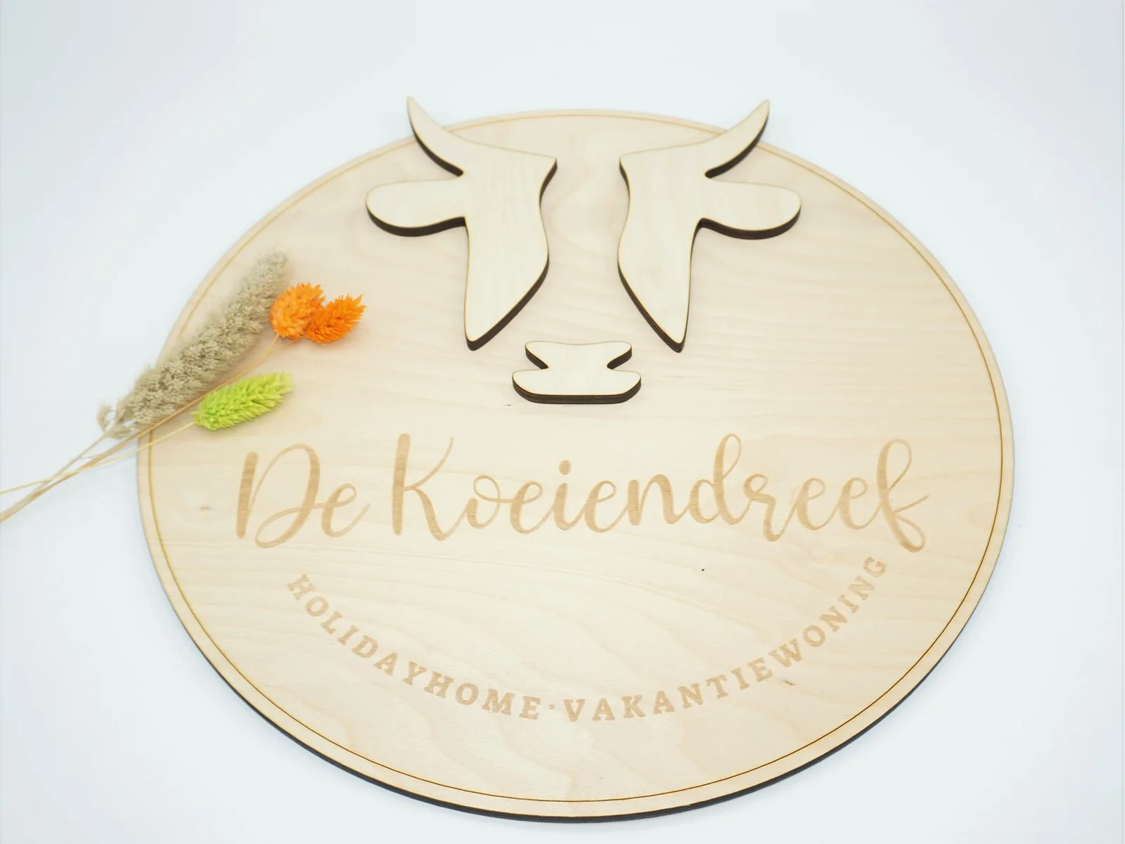 A layered and engraved wooden sign for De Koeiendreef holiday home
