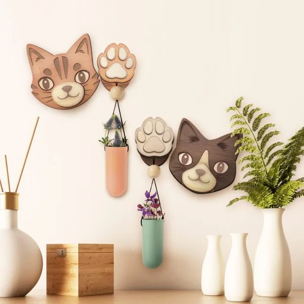 Cat-shaped wooden wall hooks holding small planters