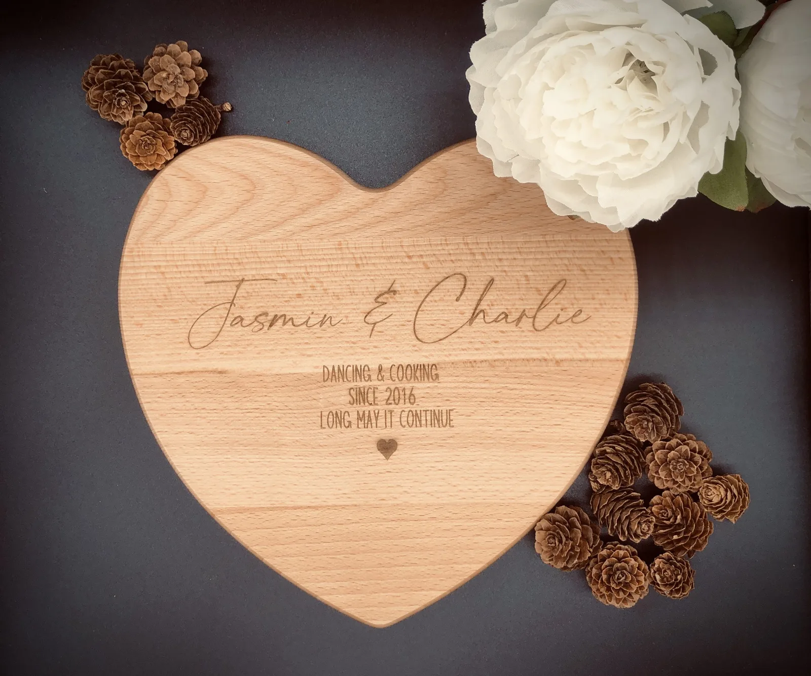 A heart-shaped wooden board engraved for Jasmin and Charlie