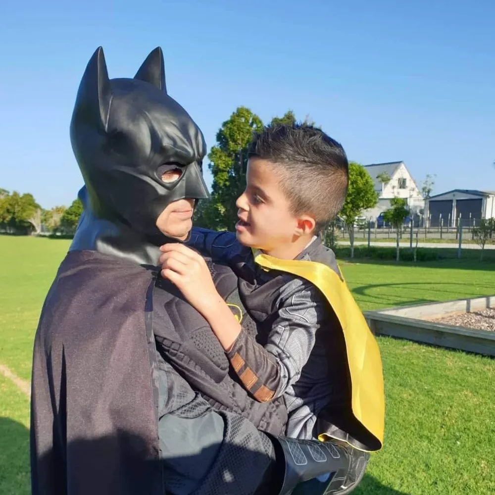 Kit Walker dressed as Batman greeting a child dressed as Robin