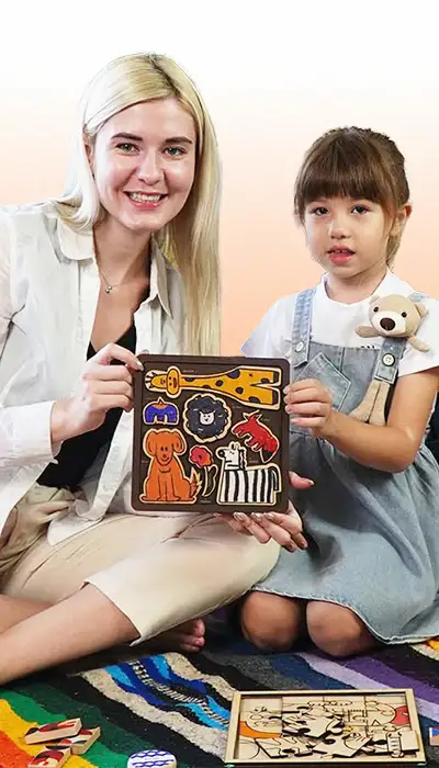 An adult and a child holding a colourful laser-engraved artwork panel