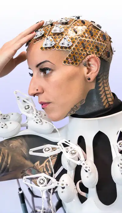A model wearing a laser-cut geometric headpiece and sculptural collar